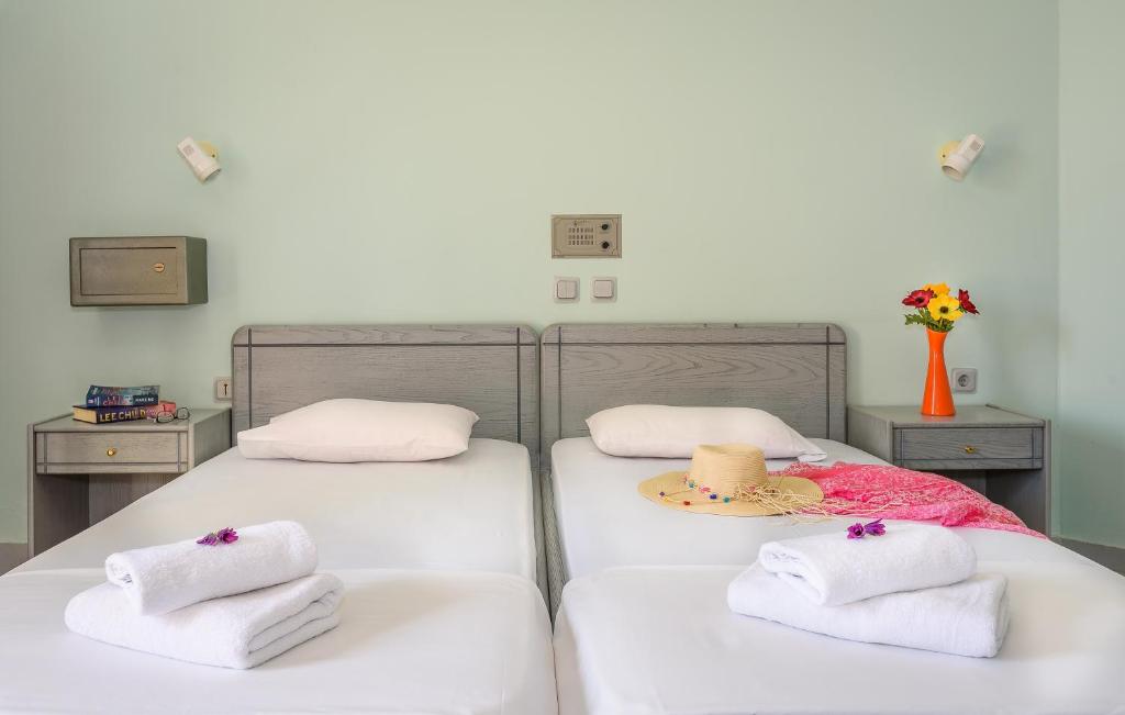 two beds with towels and a hat on them at Louladakis Apartments in Kolymvari