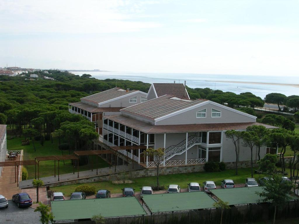 a large house with cars parked in front of it at Hotel Nuevo Portil Golf in El Rompido