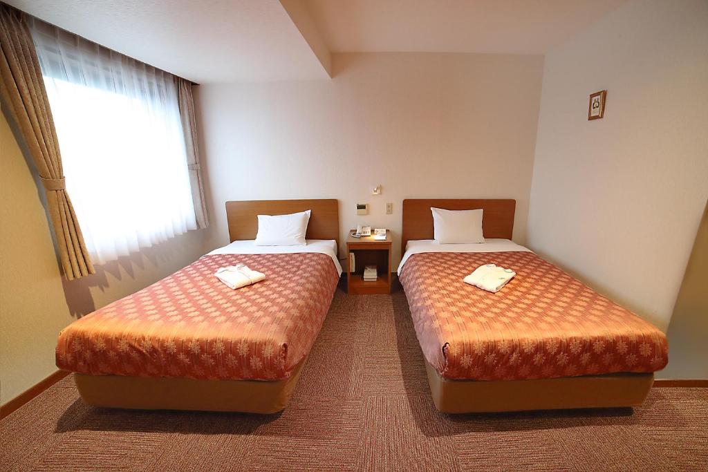 Postel nebo postele na pokoji v ubytování Kumegawa Wing Hotel