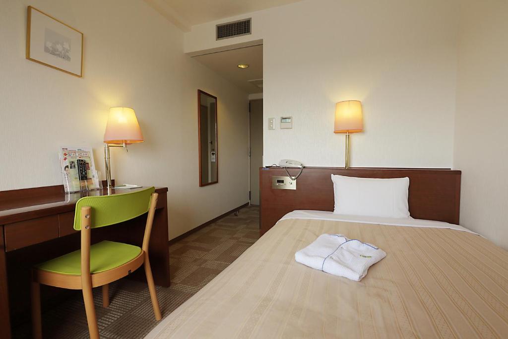 Postel nebo postele na pokoji v ubytování Kumegawa Wing Hotel