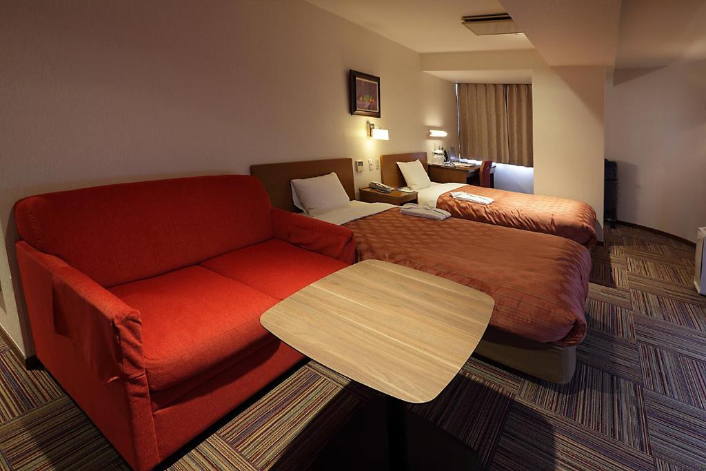 Postel nebo postele na pokoji v ubytování Kumegawa Wing Hotel