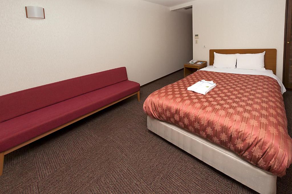 Postel nebo postele na pokoji v ubytování Kumegawa Wing Hotel