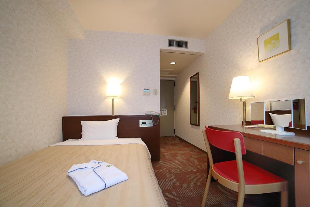 Postel nebo postele na pokoji v ubytování Kumegawa Wing Hotel