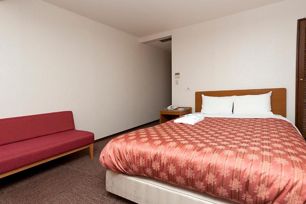 Postel nebo postele na pokoji v ubytování Kumegawa Wing Hotel