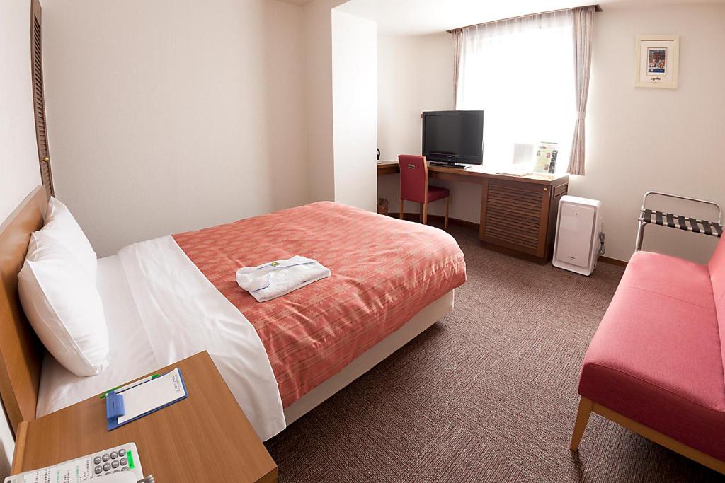 Postel nebo postele na pokoji v ubytování Kumegawa Wing Hotel