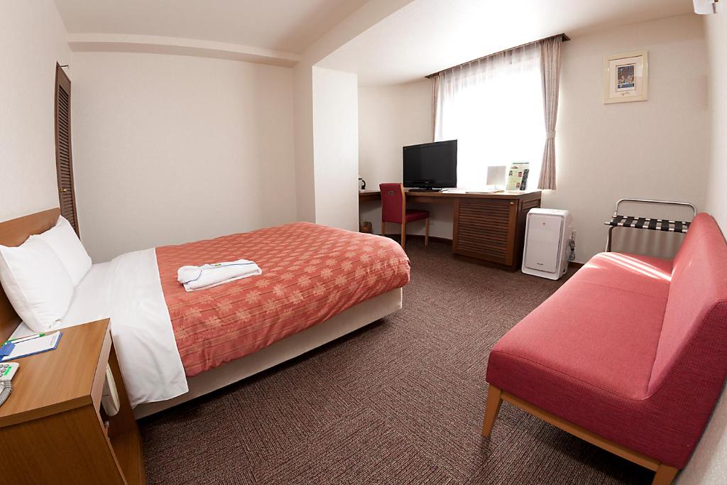 Postel nebo postele na pokoji v ubytování Kumegawa Wing Hotel