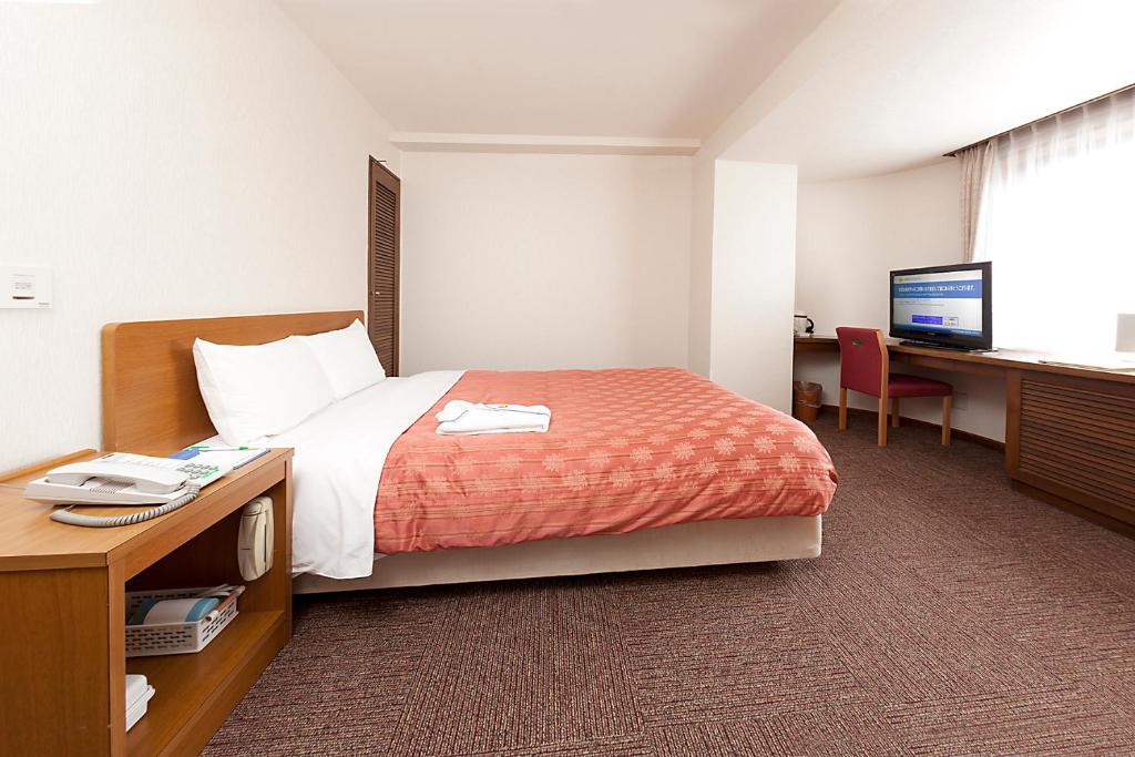 Postel nebo postele na pokoji v ubytování Kumegawa Wing Hotel
