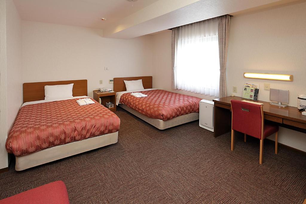Postel nebo postele na pokoji v ubytování Kumegawa Wing Hotel