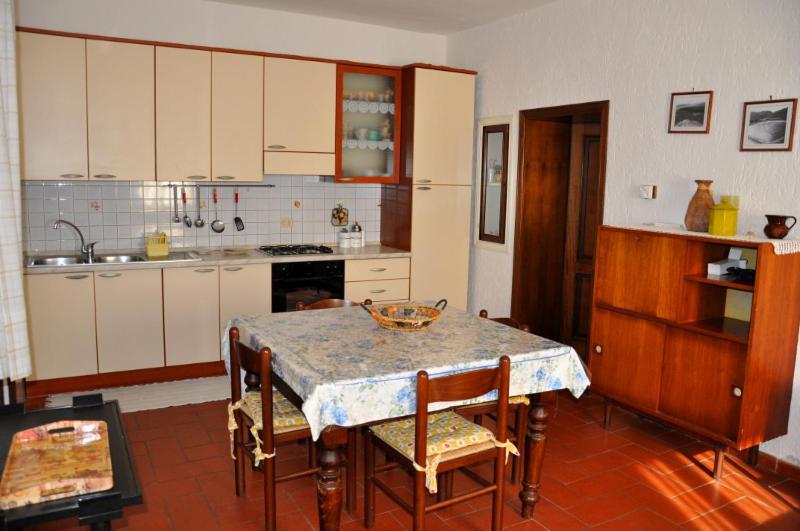 a kitchen with a table and some chairs and a table and a kitchen at Appartamenti Podere 270 in Punta Ala