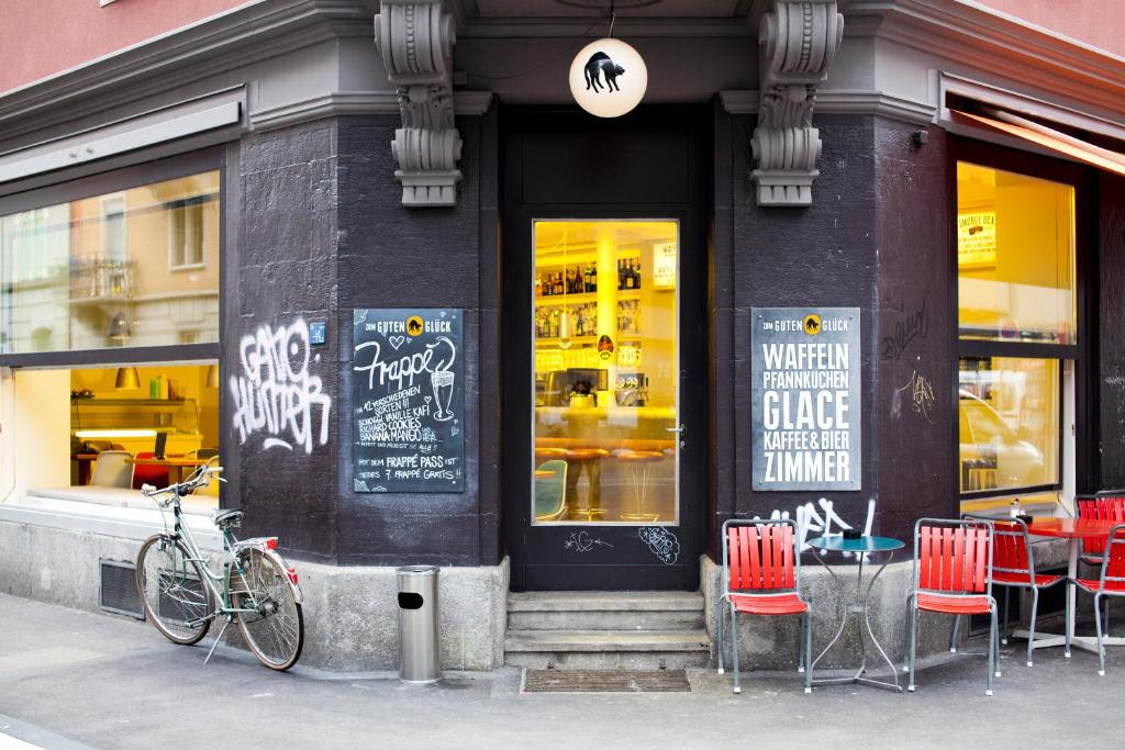 蘇黎世的住宿－好運旅館，一辆自行车停在商店前面,里面摆放着桌椅