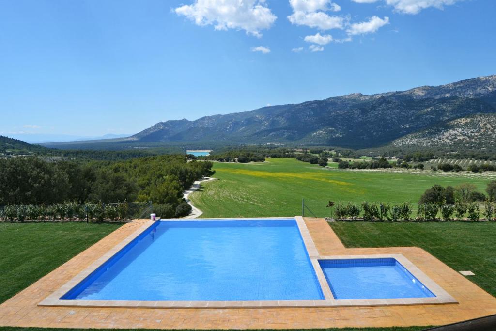 an overhead view of a swimming pool on a golf course at Hotel Rural Ibipozo in El Almicerán