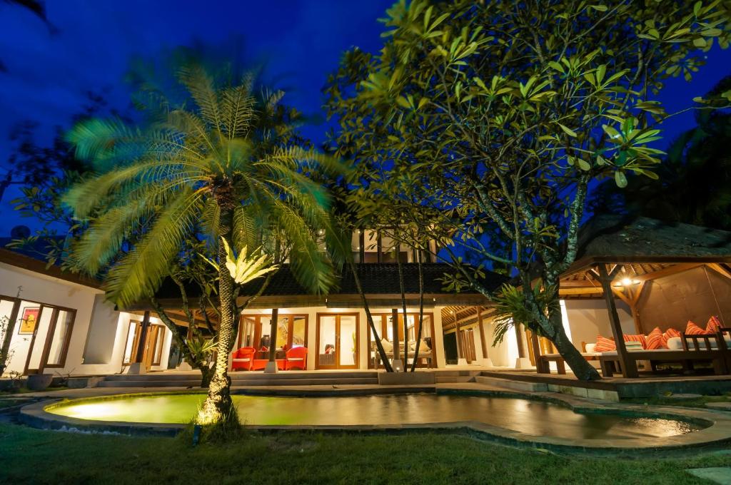 a villa with a swimming pool at night at Jasmina Estate in Seminyak