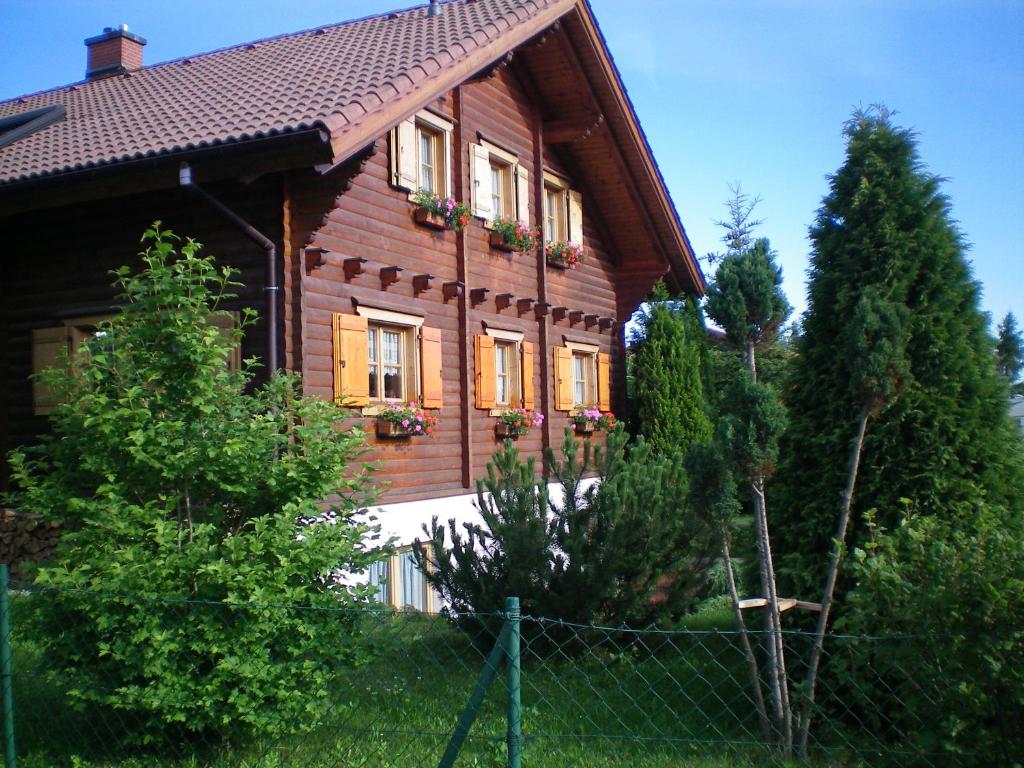 een houten huis met een hek ervoor bij Zum Stadtwald in Spremberg