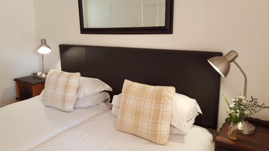 Un pat sau paturi într-o cameră la Camdeboo Cottages