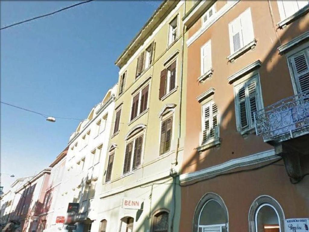 普拉的住宿－Apartments Todorovic，一座黄色的建筑,有很多窗户