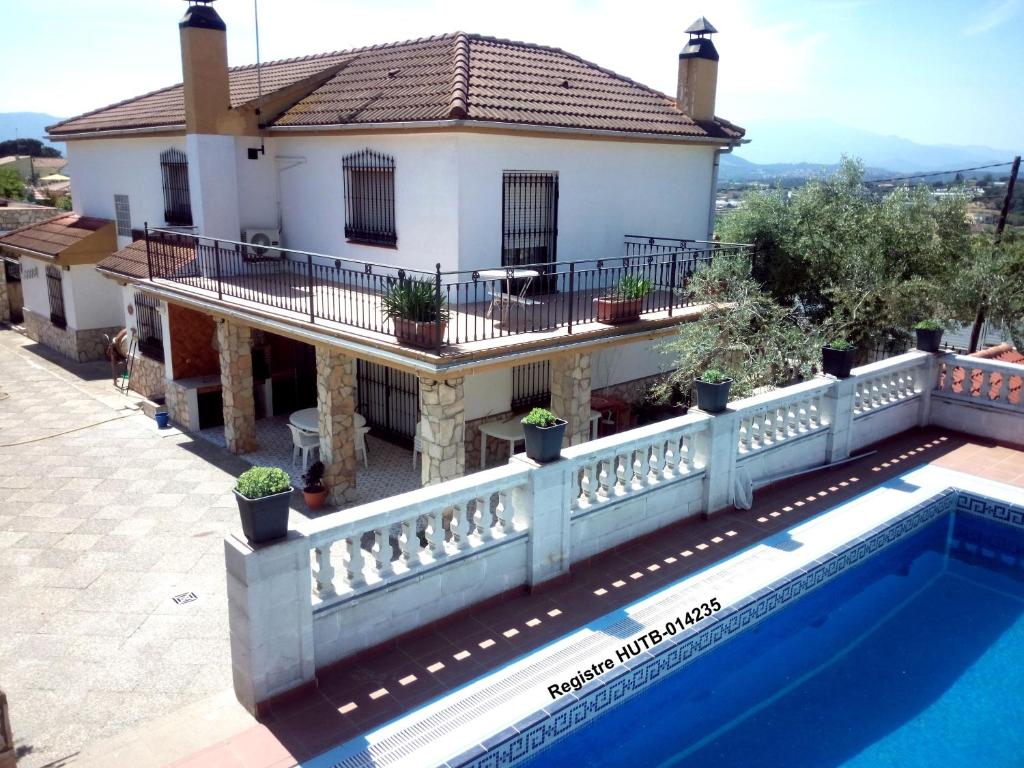 eine Villa mit einem Pool vor einem Haus in der Unterkunft Armonía in Tordera