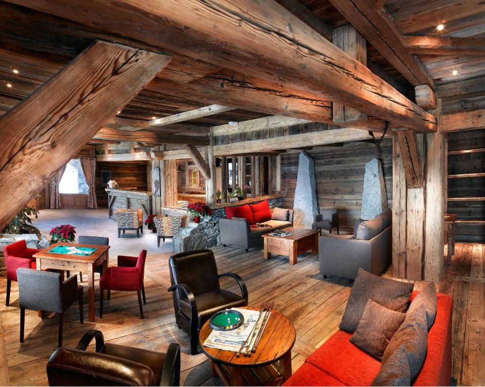 una sala de estar con sofás, sillas y mesas. en CGH Résidences & Spas La Ferme Du Val Claret, en Tignes