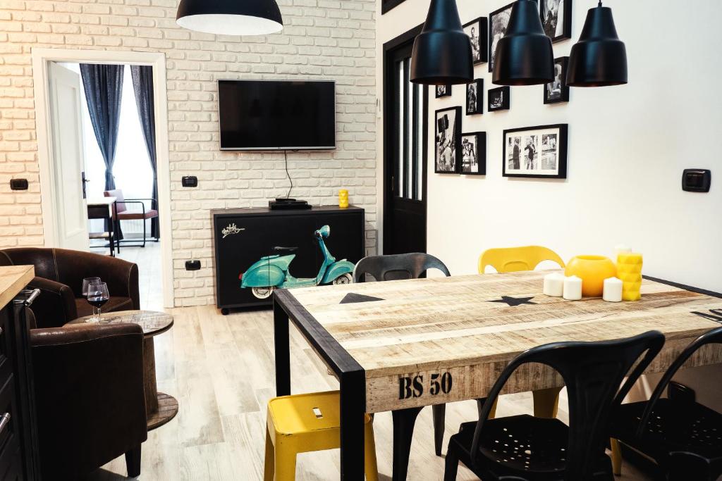 ローマにあるBMGA l Stylish Industrial Termini Apartmentのリビングルーム(木製テーブル、椅子付)