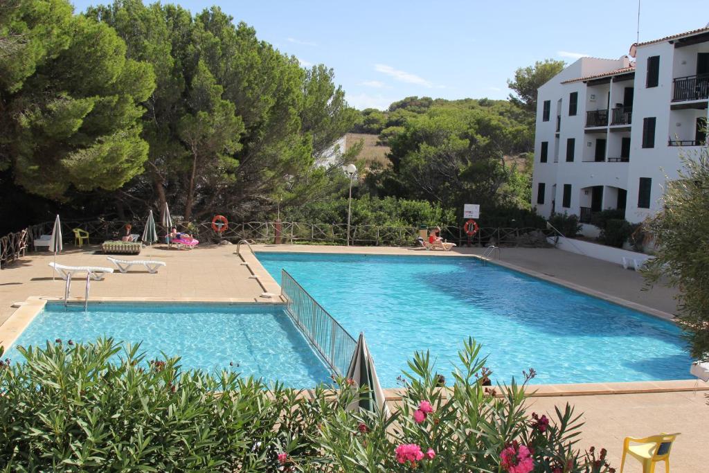 una gran piscina azul junto a un edificio en Apartamentos Sol Isla en Arenal d'en Castell