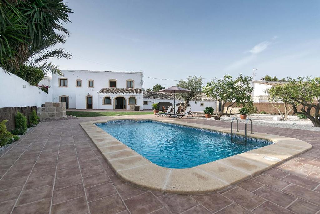 a swimming pool in front of a house at Villa Finca Sol Javea in Jávea