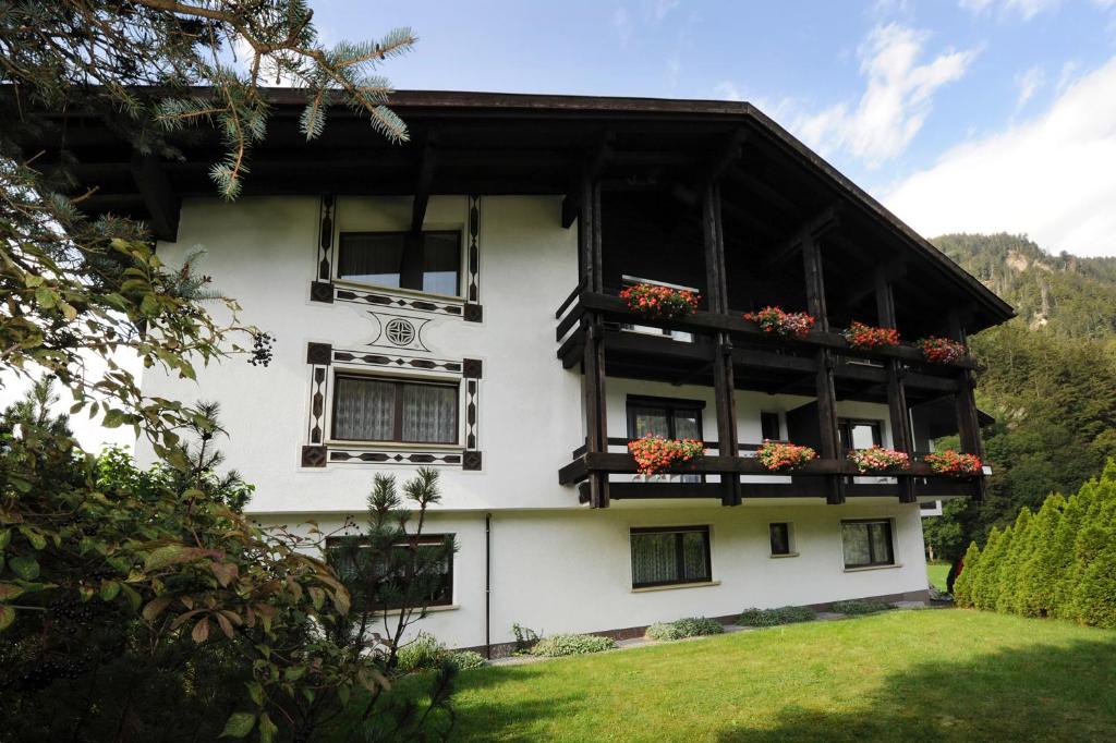 a white building with flower boxes on the windows at Haus Karin in Sankt Gallenkirch