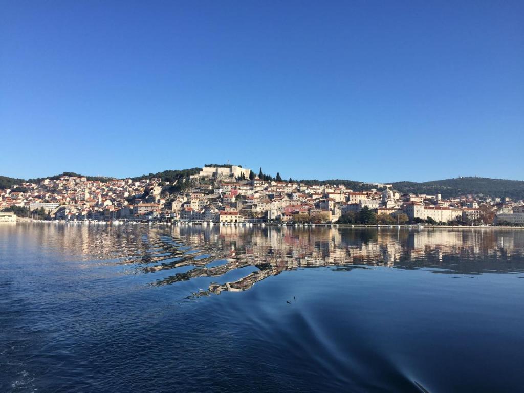 a large body of water with a town on a hill at Apartman Luna in Šibenik