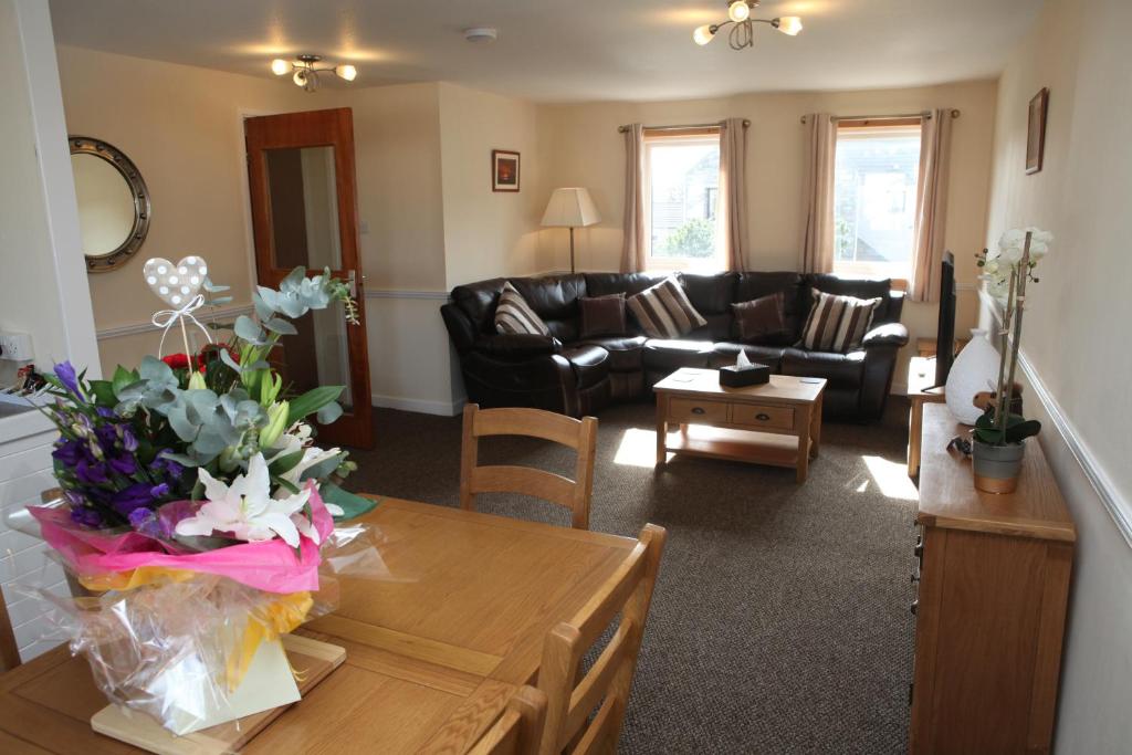 uma sala de estar com uma mesa com flores em Castleyards Apartment 2 em Kirkwall