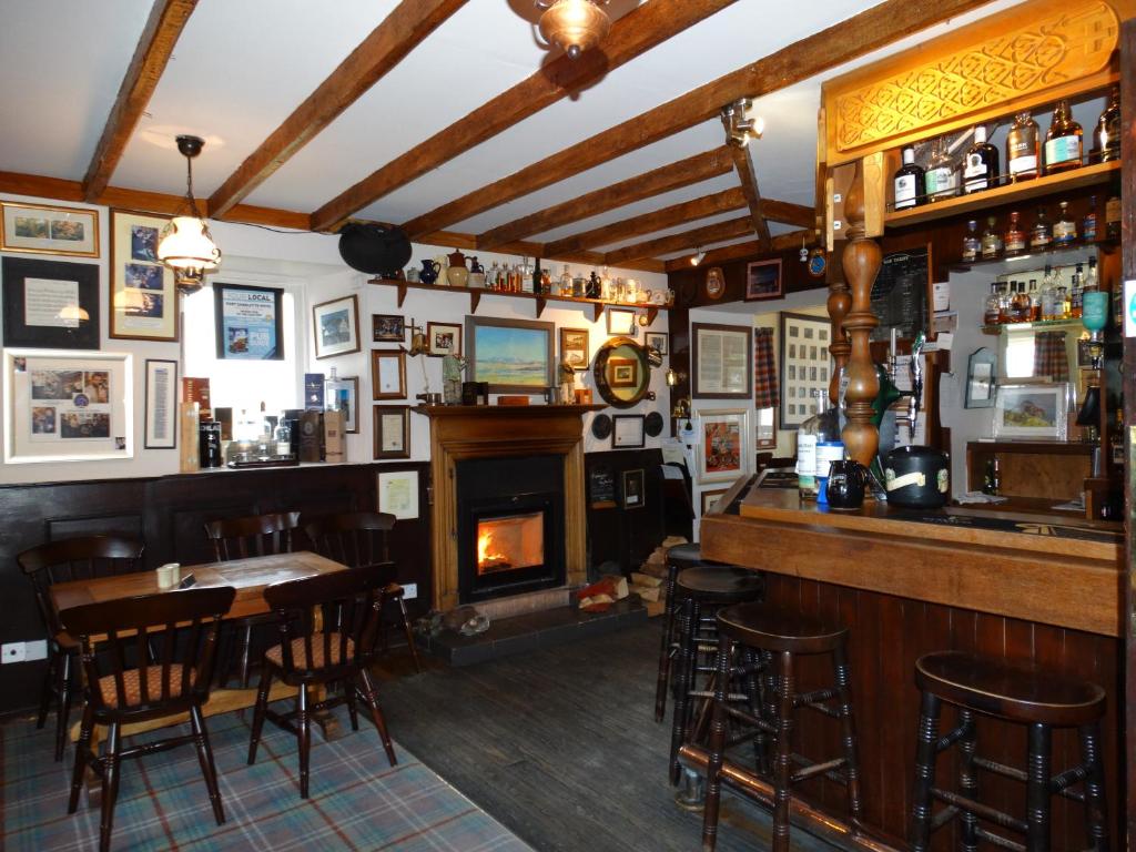 a bar with a fireplace and a table and chairs at Port Charlotte Hotel in Port Charlotte