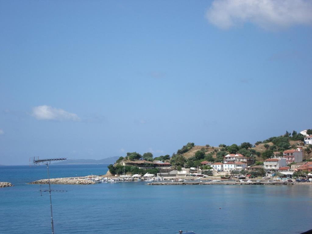 a large body of water with houses on a hill at Hotel Korakakis Beach in Finikounta