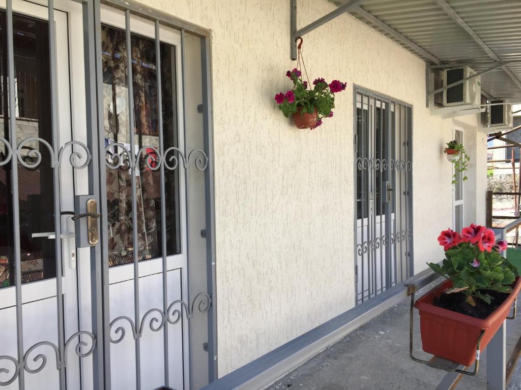 a front door of a building with flowers in a pot at Guest house Y morya in Sukhum