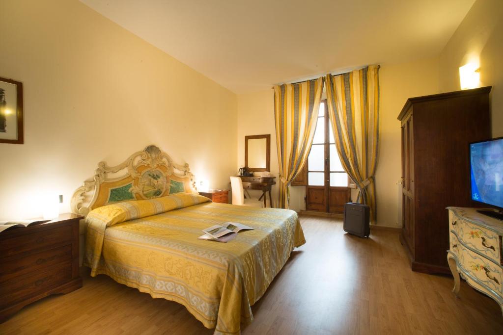 een slaapkamer met een kingsize bed en een televisie bij Locanda Orchidea in Florence