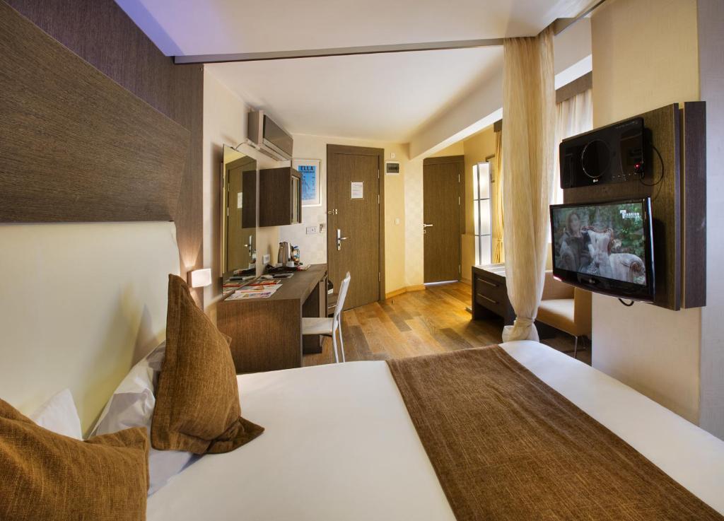 イスタンブールにあるジャズ ホテル ニサンタシェのベッドとテレビが備わるホテルルームです。