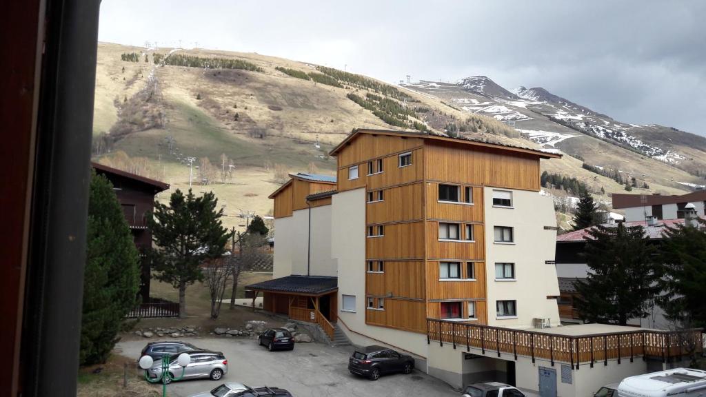 une vue d'un bâtiment avec une montagne en arrière-plan dans l'établissement Vacancéole - Résidence Alpina Lodge, à Les Deux Alpes