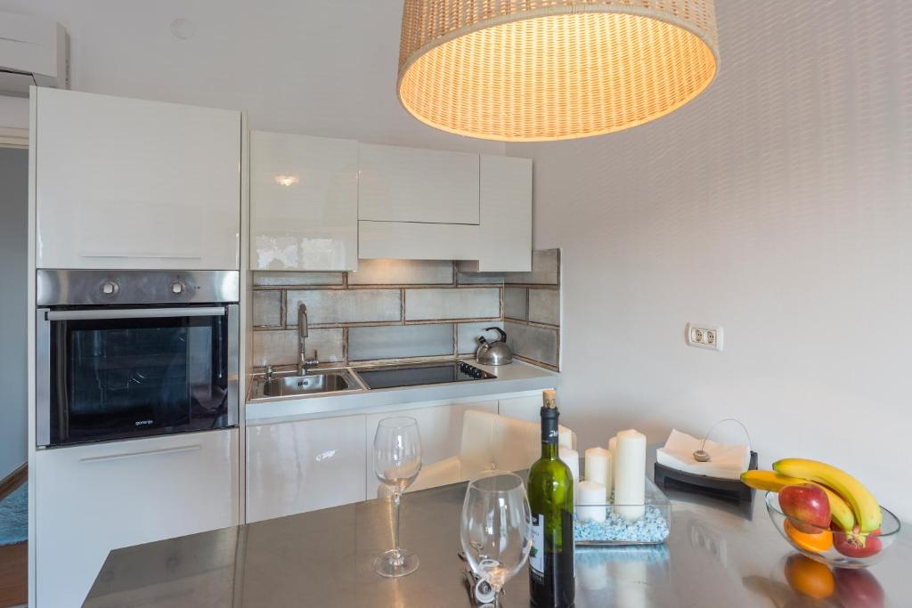 a kitchen with a counter with wine glasses and a light at Monte & Paradiso in Pula