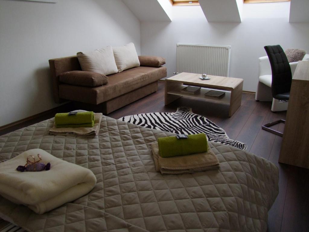 - un salon avec un lit et un canapé dans l'établissement Korzó Apartman, à Kőszeg