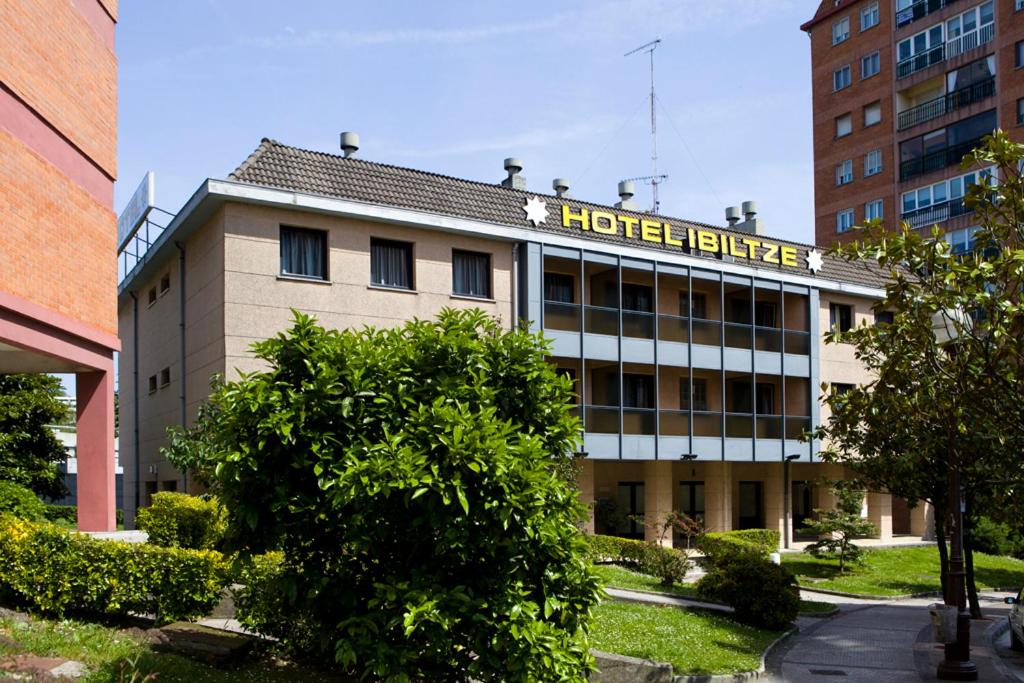 a hotel building with a sign on top of it at Hotel Ibiltze in Lasarte
