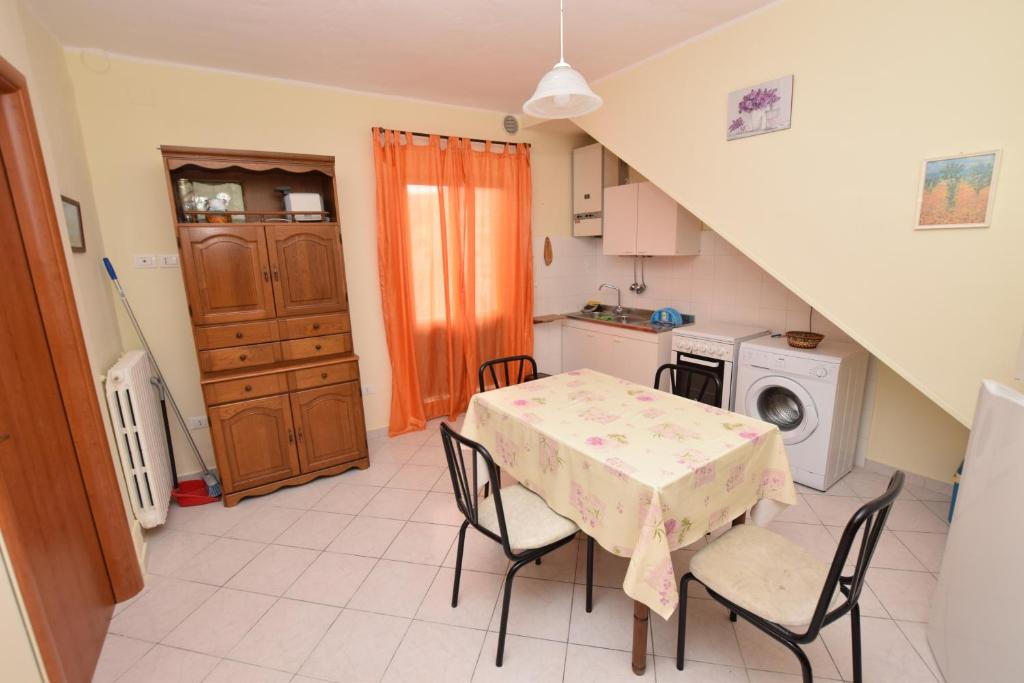 uma cozinha com mesa e cadeiras num quarto em La Casetta di Adriana em San Vito Chietino