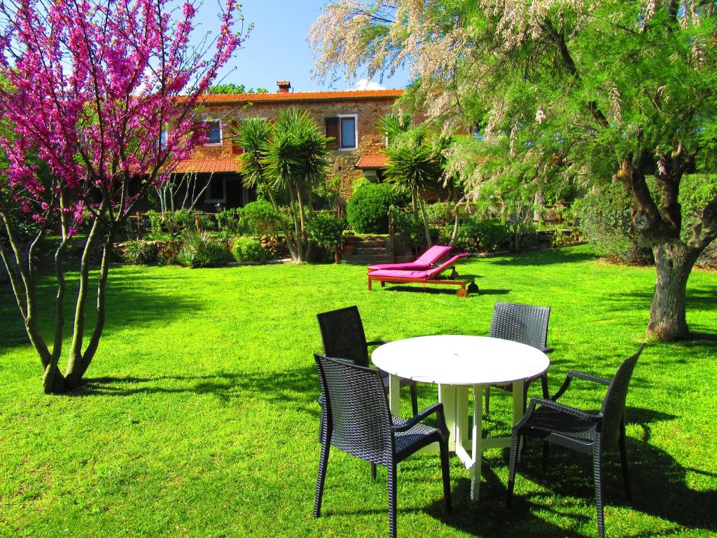 a table and chairs in the yard of a house at Agriturismo Serignano alle Rocchette in Castiglione della Pescaia