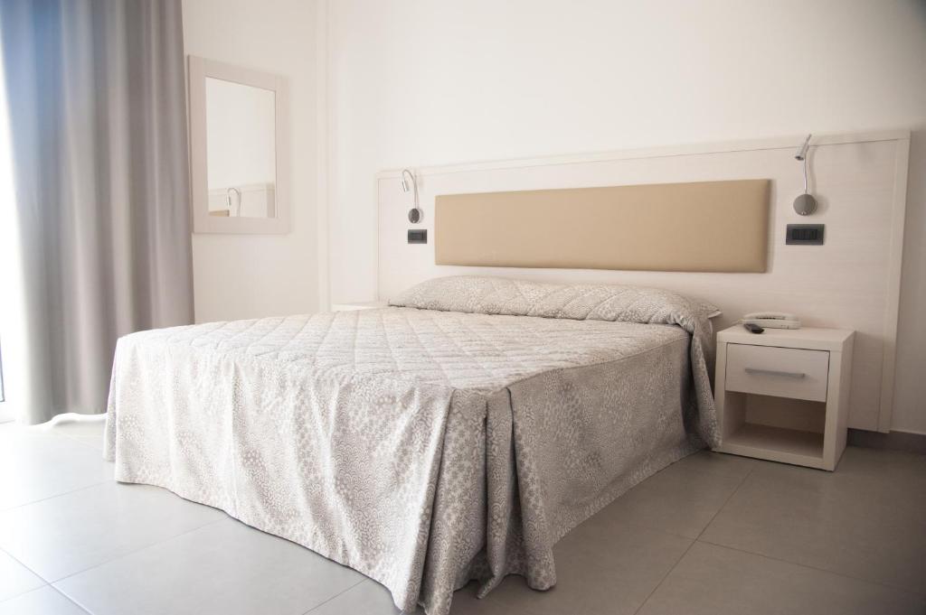 um quarto branco com uma cama com um cobertor branco em Residence Hotel Albachiara em Rimini