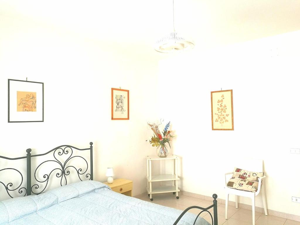 オートラントにあるAppartamento Otrantoの白いベッドルーム(ベッド1台、椅子付)