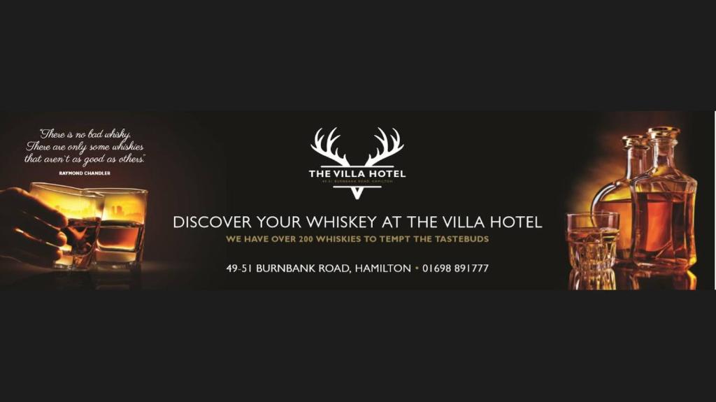 una bottiglia di whisky, un bicchiere e una bottiglia di alcol di Villa Hotel a Hamilton