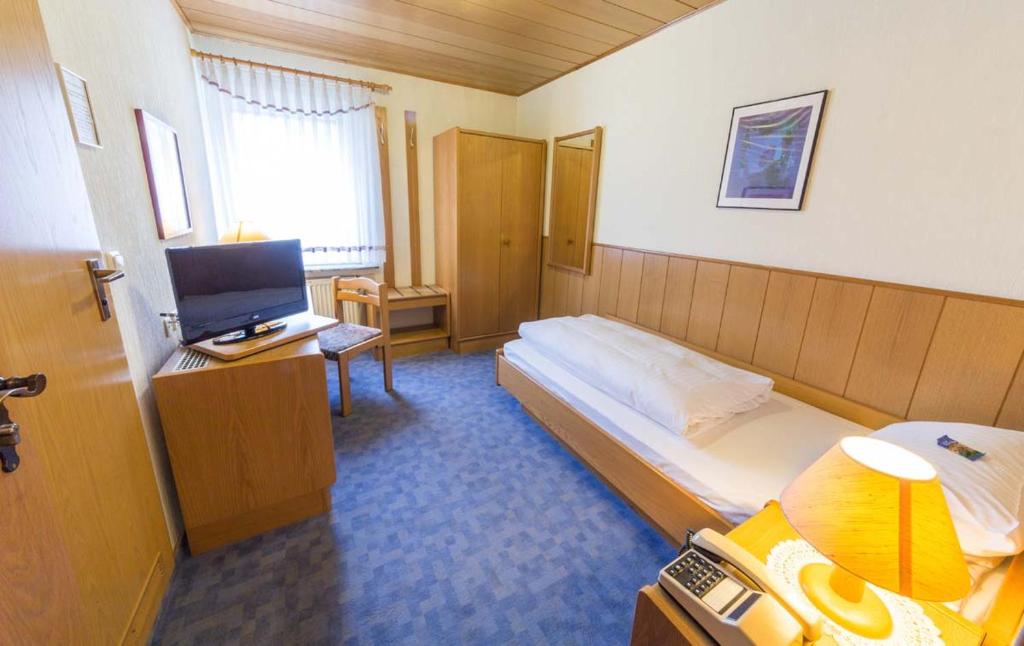 a hotel room with a bed and a television at Hotel Thielmann in Mittenaar