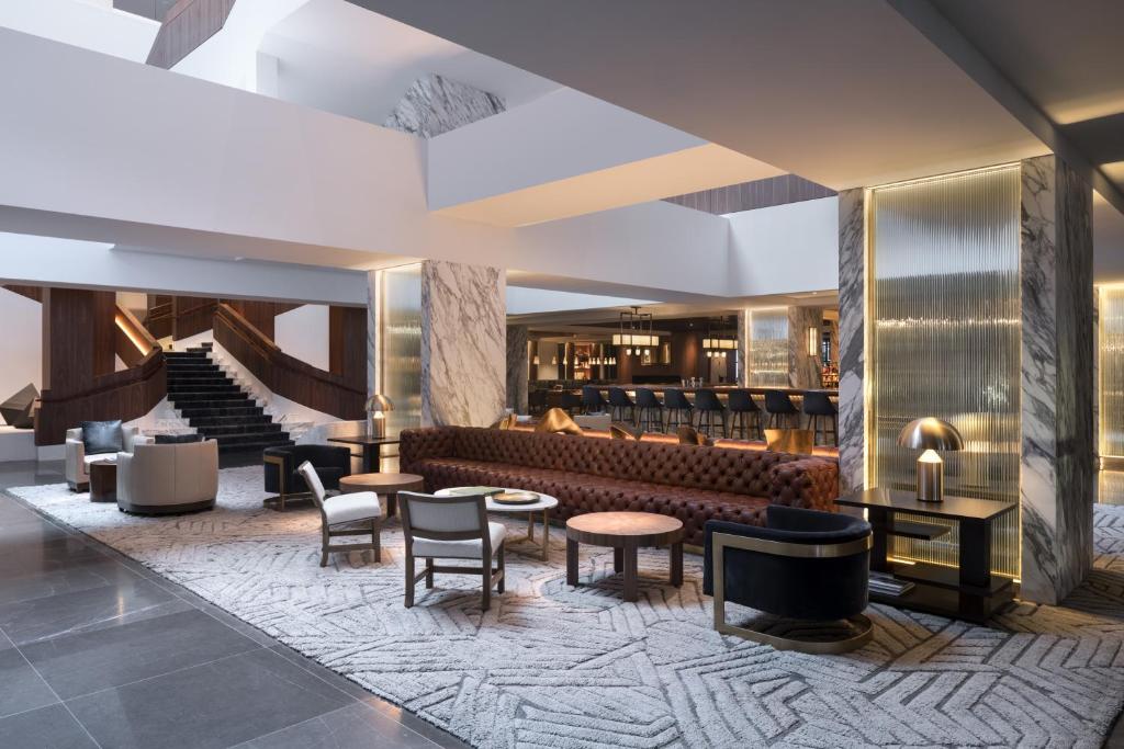 a lobby with a couch and tables and chairs at Four Seasons Hotel Houston in Houston