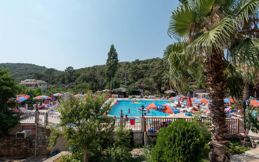 a pool at a resort with people and umbrellas at Oludeniz Region Random Rooms by LookBookHoliday in Oludeniz