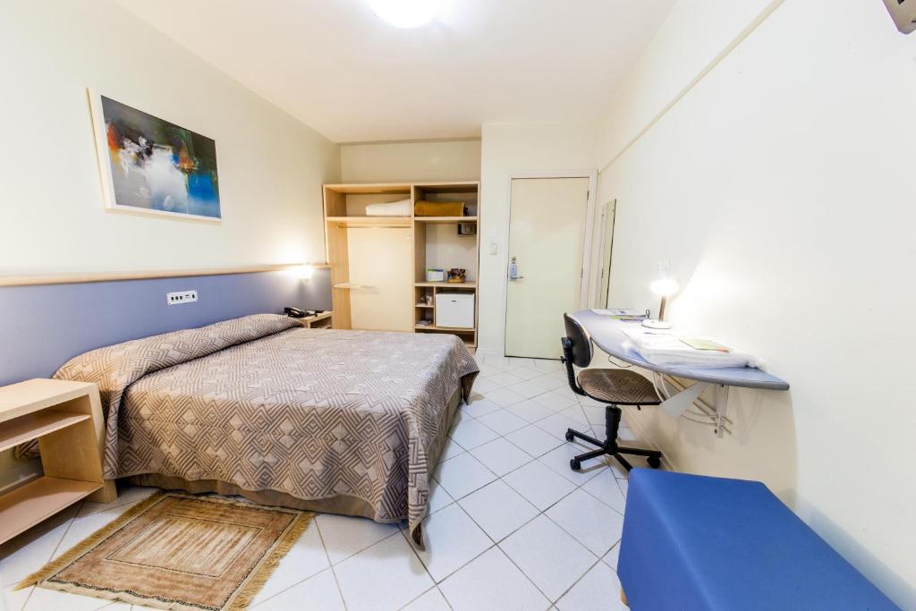 1 dormitorio con cama y escritorio. en Asppen Hotel, en Chapecó