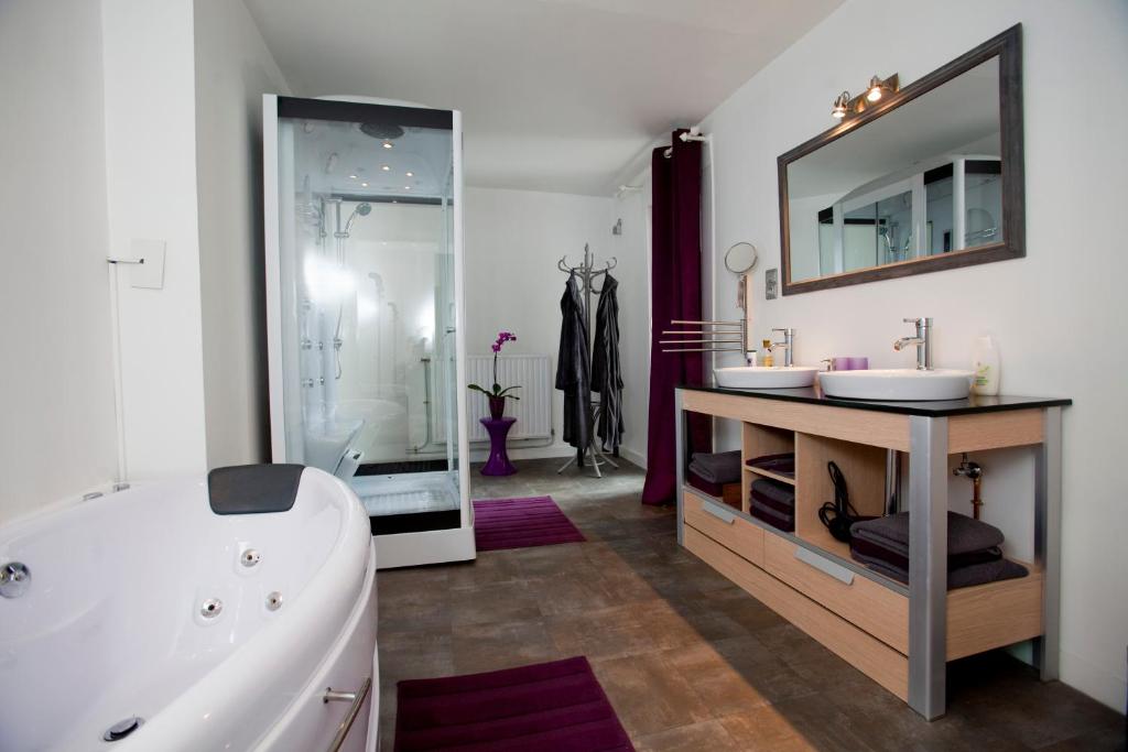 bagno con 2 lavandini, vasca e specchio di B&B Luxe Suites 1-2-3 ad Anversa