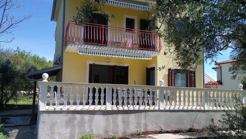 Casa con valla blanca y balcón en Apartments Nina, en Ravni
