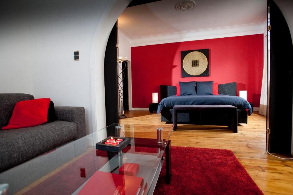 - un salon avec un lit et un mur rouge dans l'établissement B&B Luxe Suites 1-2-3, à Anvers