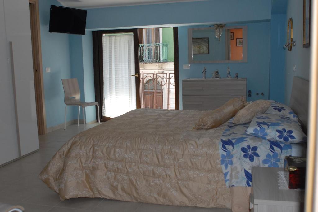 a bedroom with a bed and a dresser and a window at Dietro Piazza Maggiore in Sulmona