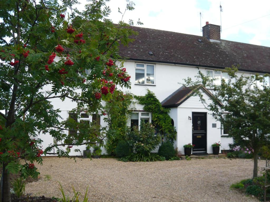 una casa blanca con rosas rojas delante de ella en The Kings' House en Bramfield